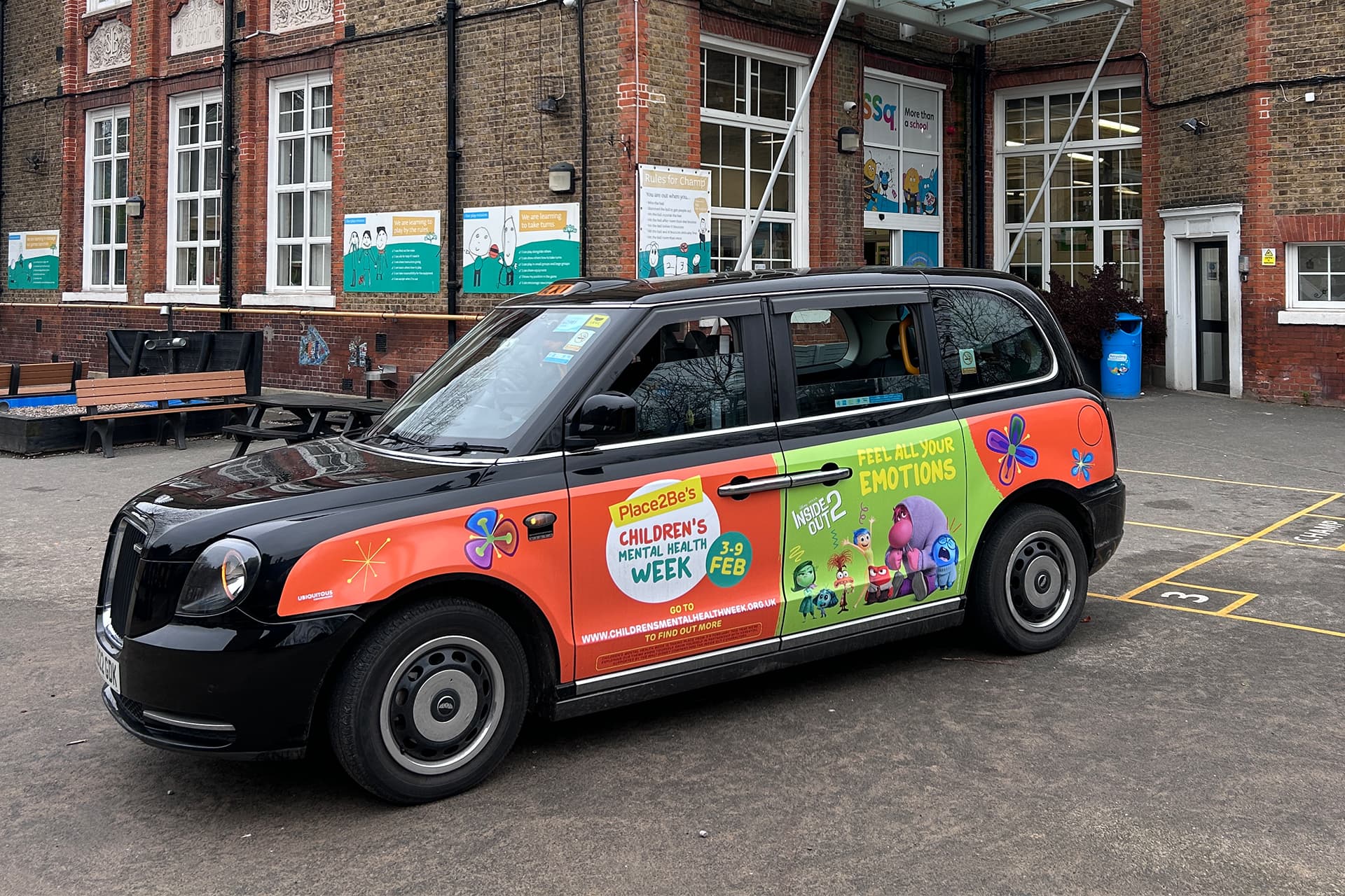 Place2Be Children's Mental Health Week taxi wrap parked outside a school